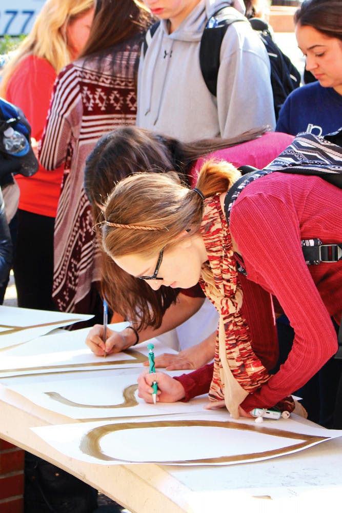 UF students gather Friday morning to support Florida State University amid the recent tragedy by signing their names and messages of encouragement on posters.