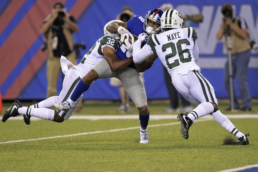 New York Giants' Roger Lewis (18) is tackled by New York Jets' Marcus Maye (26) and Juston Burris (32) during the first half of a preseason NFL football game Saturday, Aug. 26, 2017, in East Rutherford, N.J. (AP Photo/Bill Kostroun)
