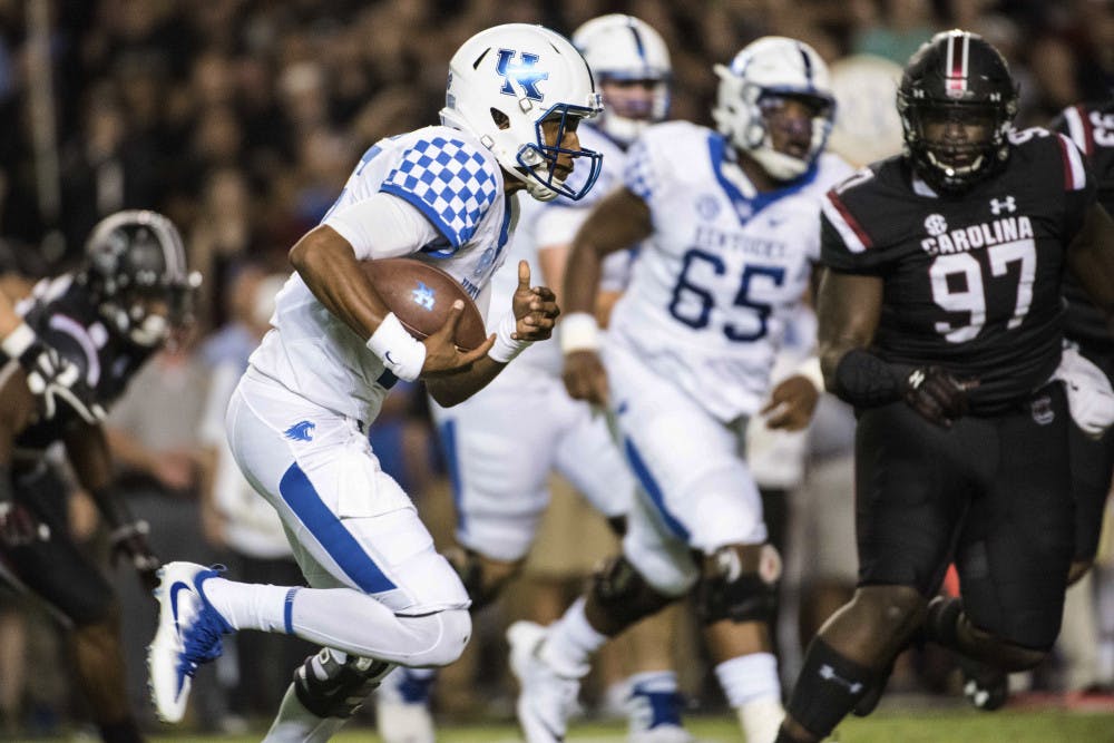 Kentucky quarterback Stephen Johnson carries during the first half as South Carolina's Kobe Smith defends during an NCAA college football game Saturday, Sept. 16, 2017, in Columbia, S.C. (AP Photo/Sean Rayford)