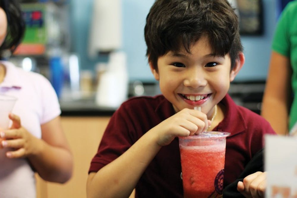 <p>Peter Nguyen, 9, enjoys a strawberry slush with green apple jelly at Lollicup on Monday afternoon. “I like it because it tastes good,” Nguyen said. His favorite drink is the Oreo Snow.</p>