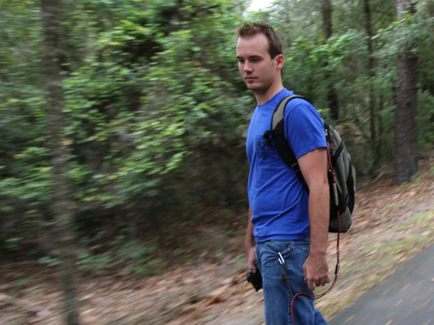 Aaron King, UF alumnus and founder of RedRock Board Shop, rides down the Gainesville-Hawthorne State Trail on one of his electric longboards Oct. 9. The electronics for a board cost $300.