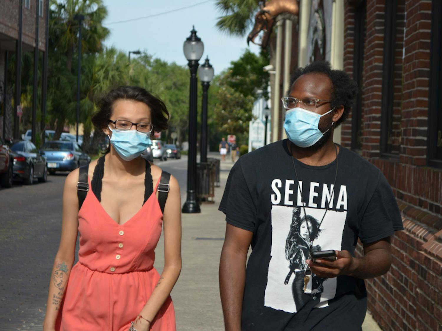Denise Garcia and Jeffery Davis wear face masks in downtown Gainesville. The commission voted Tuesday to end the face mask requirement in its emergency order. 