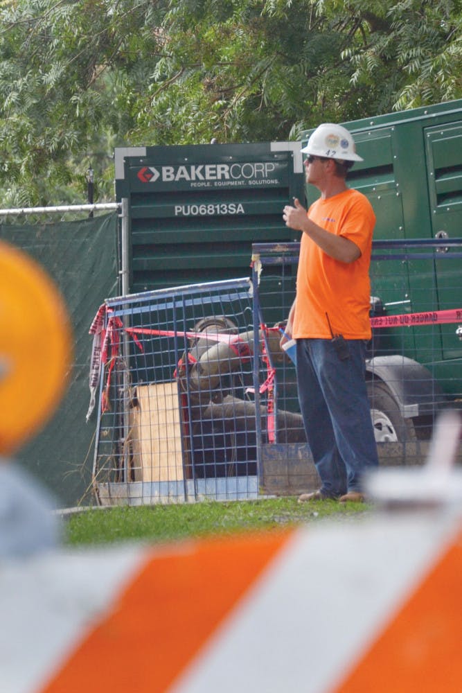 AJ Coons, a 34-year-old Skanska employee, directs a heavy-machinery driver removing debris from the Reitz Union construction site Tuesday. Coons said he hung out with his family and ate barbeque during his Labor Day holiday.