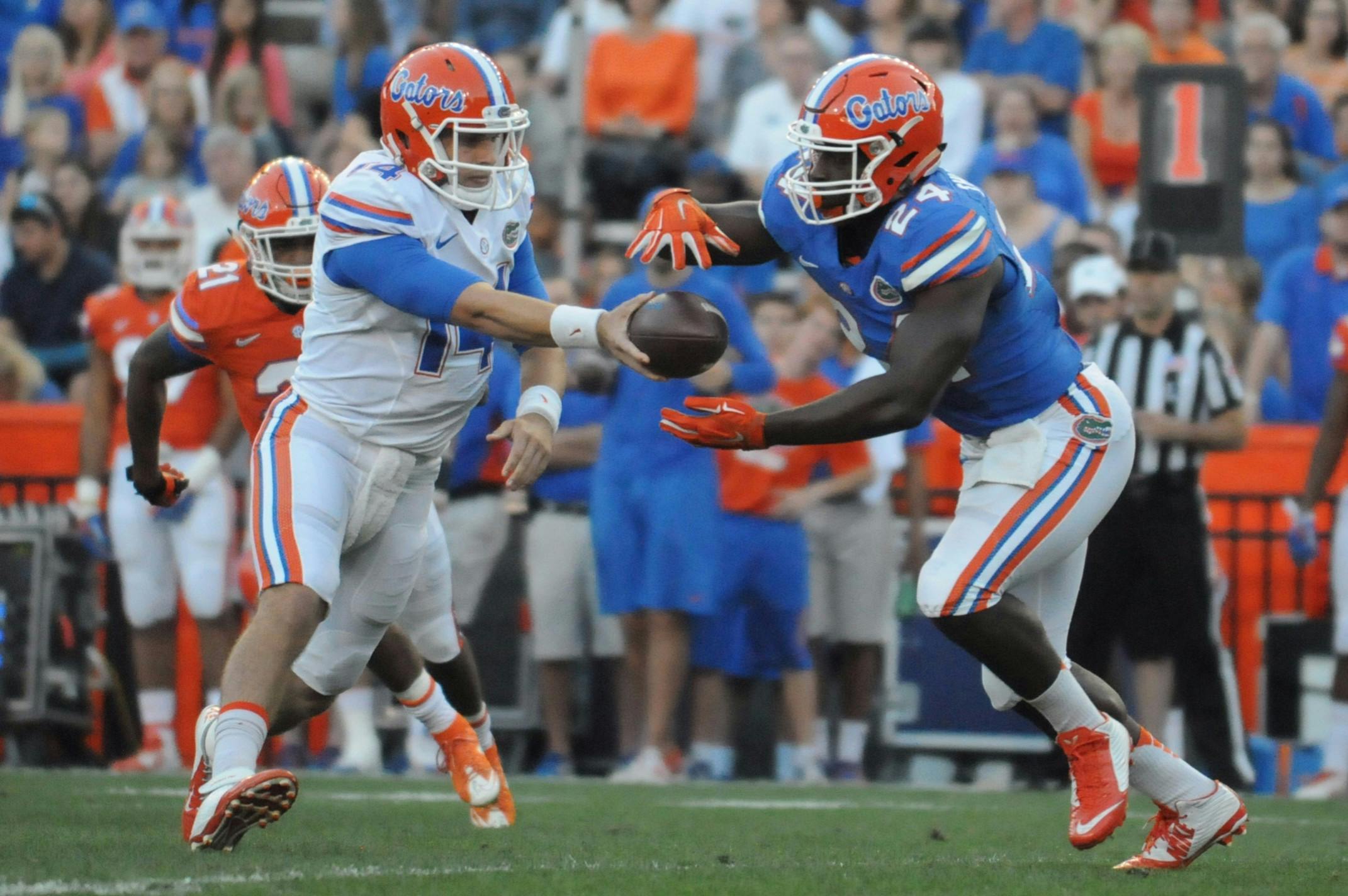 Quarterback Luke Del Rio (14) hands the ball to running back Mark Thompson (24) during the Orange &amp; Blue Debut on April 8, 2016, at Ben Hill Griffin Stadium.