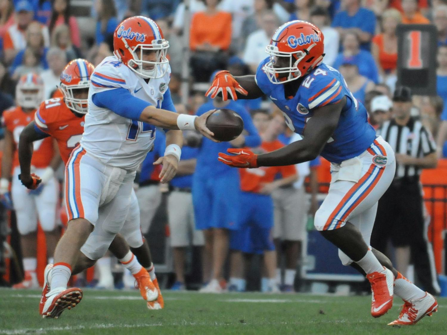 Quarterback Luke Del Rio (14) hands the ball to running back Mark Thompson (24) during the Orange & Blue Debut on April 8, 2016, at Ben Hill Griffin Stadium.