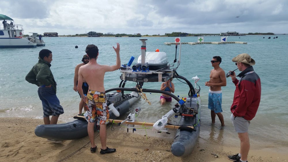 <p><span><span>Members of UF’s Machine Intelligence Laboratory work on the NaviGator-Autonomous Maritime System, which is an 18-foot long boat with a robot mounted on top that can drive the machine by itself. The team took fourth in the 2018 Maritime RobotX Challenge in Hawaii. Courtesy to The Alligator.</span></span></p>