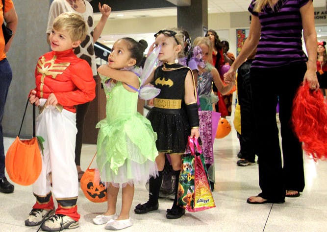 A Baby Gator pre-kindergarten class lines up outside of the Game Room at the Reitz Union to get treats from manager Charlotte Dare on Thursday. Parents donated candy for the trick-or-treating adventure.