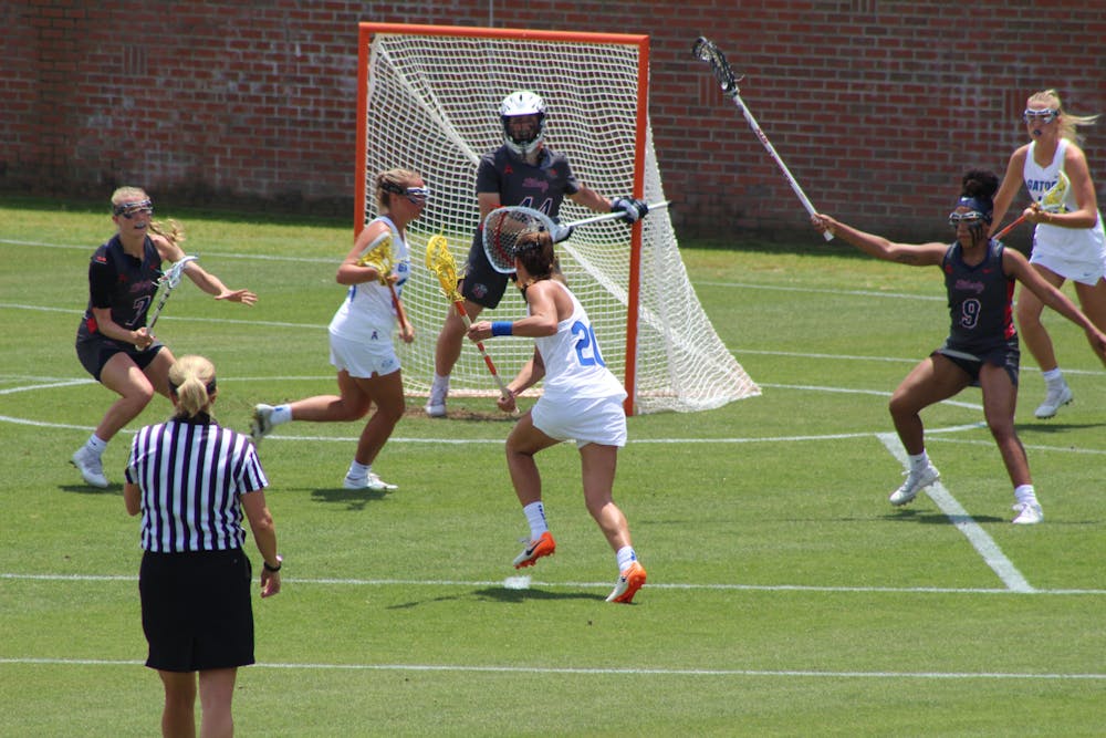 Florida attacker Brianna Harris (No. 20, center) cradles and advances towards Liberty's goal on April 28. The Gators ended their regular season with an 11th straight victory over the Flames, 17-2, to end the year 14-2. 