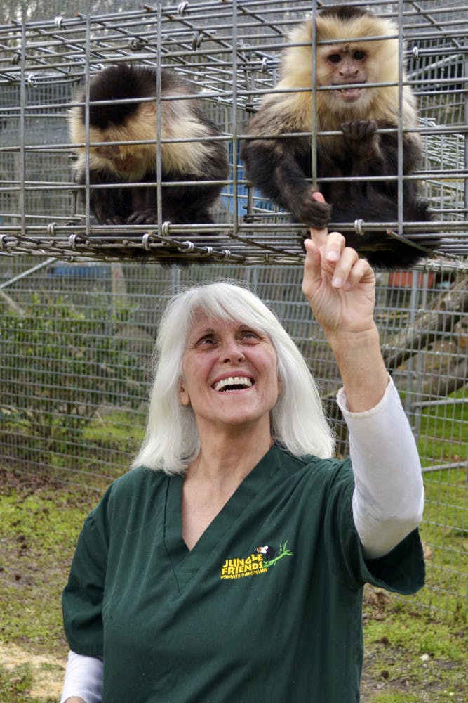 Samantha and Charlotte, a pair of white-faced capuchin monkey sisters, sit above their owner, 61-year-old Kari Bagnall, in the Jungle Friends Primate Sanctuary on Tuesday afternoon.