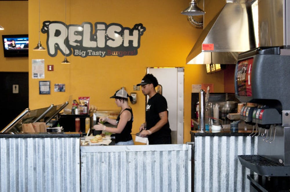 <p>Relish employees cook burgers for customers Monday evening. The restaurant has been named by Thrillist.com as the best place to eat while intoxicated in Gainesville.</p>