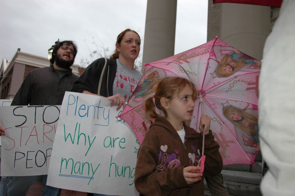Abby Mena, 6, chants with her mother, Victoria Mena, at a protest designed to get the mayor and Gainesville Commission to repeal the limit on the amount of meals a Gainesville soup kitchen can serve.