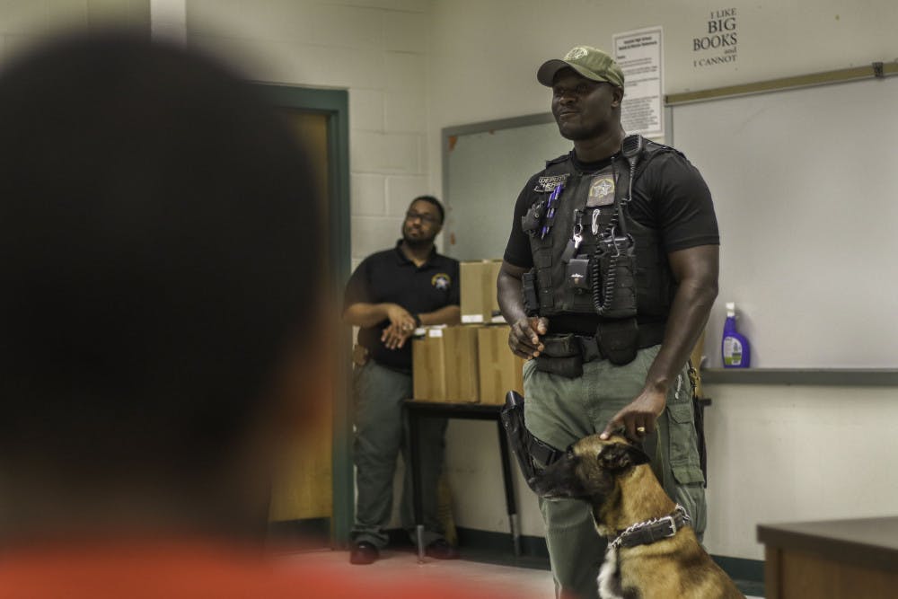 Alachua County Sheriff’s Office deputy Esau Bright, of the K-9 Unit, speaks to students Wednesday at Eastside High School with his Belgian Shepherd partner Deacon as part of BLAST: Building Lasting Relationships Between Police and Community. The event was hosted by the U.S. attorney’s office for the Northern District of Florida. Bright has worked in the K-9 Unit for 6.5 years and with Deacon for 1.5. Bright said he enjoys working with the students to “get them to know that we’re not just the bad guys.”