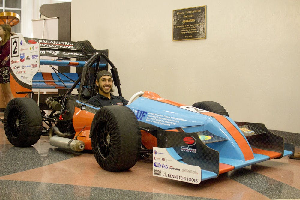 <p>Gator Motorsports project manager David Kanner poses for a photo inside Gator Motorsports’ $90,000 Formula-style racecar, which will compete in at the Formula Society of Automotive Engineers Competition at the Michigan International Speedway in May.</p>