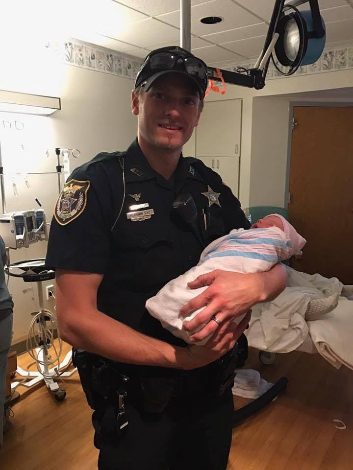 An Alachua County Sheriff's deputy holds&nbsp;John William Perry who was born&nbsp;in the ACSO parking.