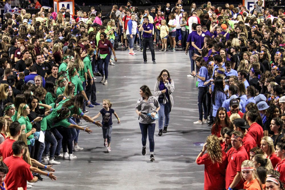 A child runs through the crowd of dancers during Dance Marathon at the O'Connell Center on Sunday. Dance Marathon is an event where volunteers must stay awake and on their feet for 26.2 hours. 