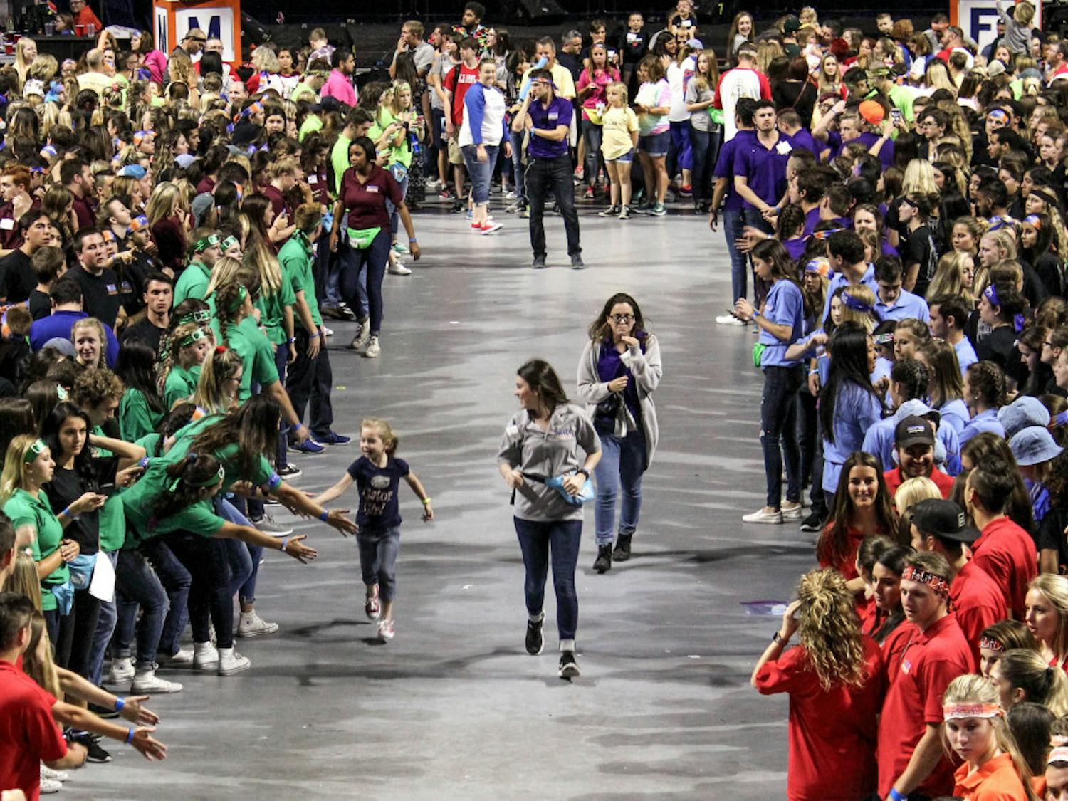 A child runs through the crowd of dancers during Dance Marathon at the O'Connell Center on Sunday. Dance Marathon is an event where volunteers must stay awake and on their feet for 26.2 hours.