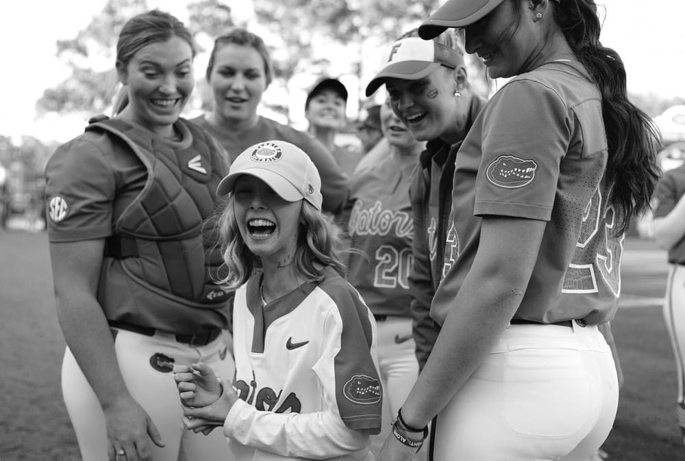Hartley interacts with her Florida teammates ahead of UF's matchup with Florida State on April 3. Hartley, her teammates and the Seminoles all drew smiley faces on their necks to replicate that of Hayden Stone, an member of Florida State's team adopted through the Friends of Jaclyn. Hayden is now cancer free!