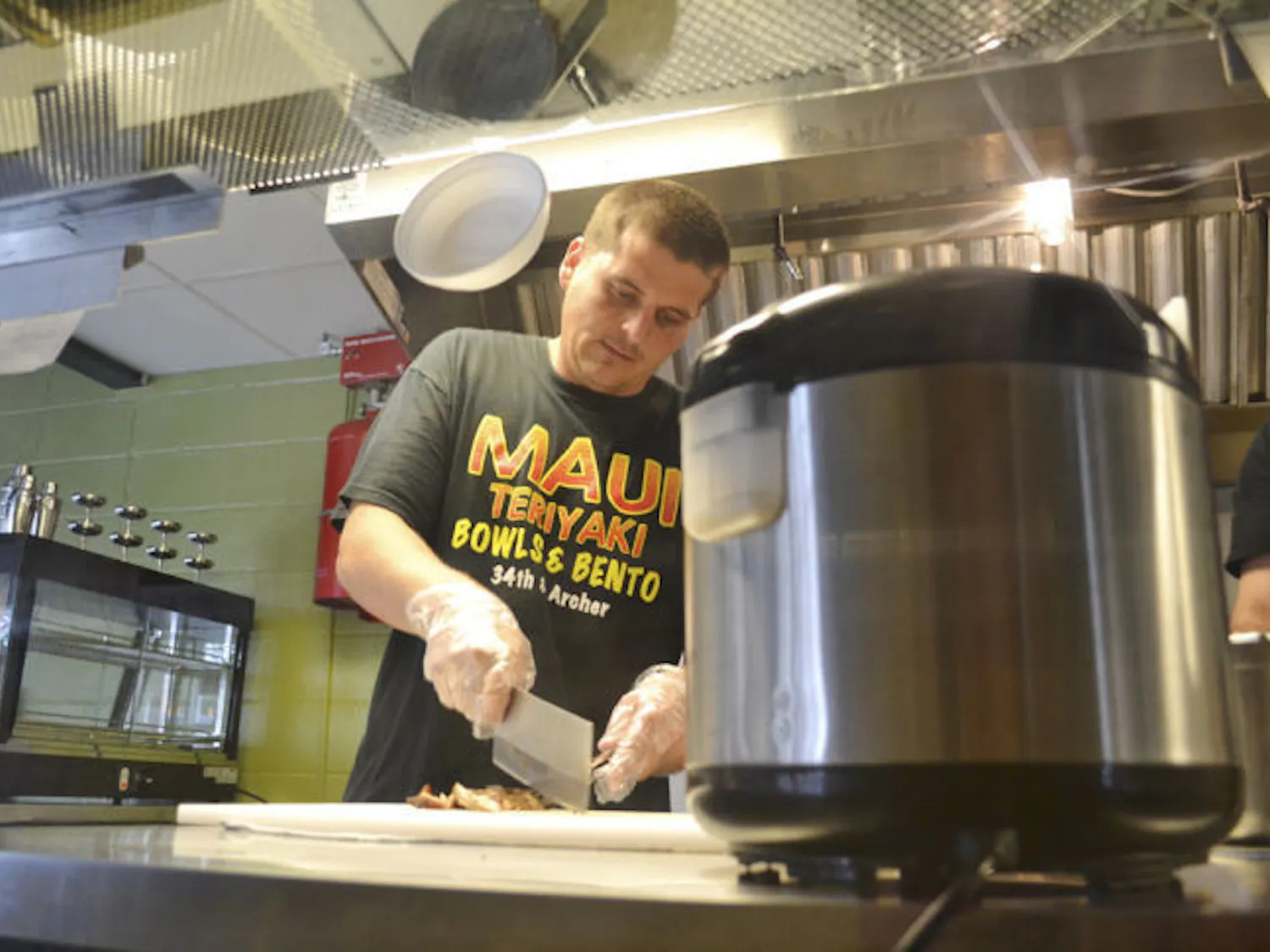 Gainesville native and Maui Grill manager Justin Amerson, 29, makes the Classic Chicken Bowl on Wednesday evening. The new restaurant opened April 21, replacing Corner - Latin Confusion.
