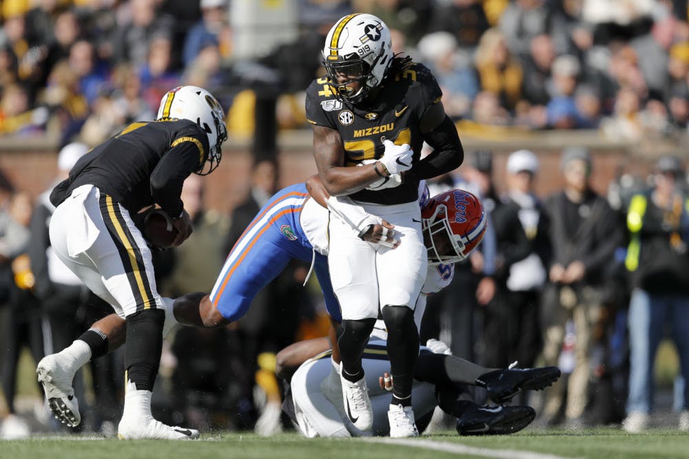 Missouri running back Larry Rountree III, front, struggles for yardage before being pulled down by Florida linebacker Jonathan Greenard during the first half of an NCAA college football game Saturday, Nov. 16, 2019, in Columbia, Mo. (AP Photo/Jeff Roberson)