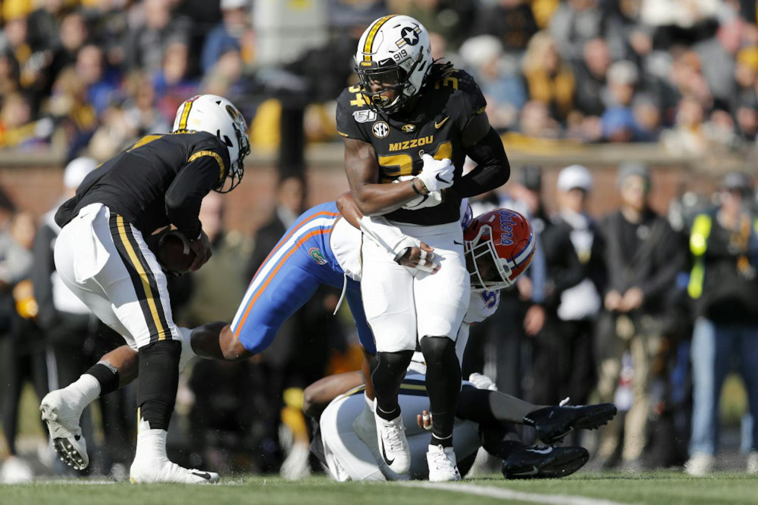 Missouri running back Larry Rountree III, front, struggles for yardage before being pulled down by Florida linebacker Jonathan Greenard during the first half of an NCAA college football game Saturday, Nov. 16, 2019, in Columbia, Mo. (AP Photo/Jeff Roberson)