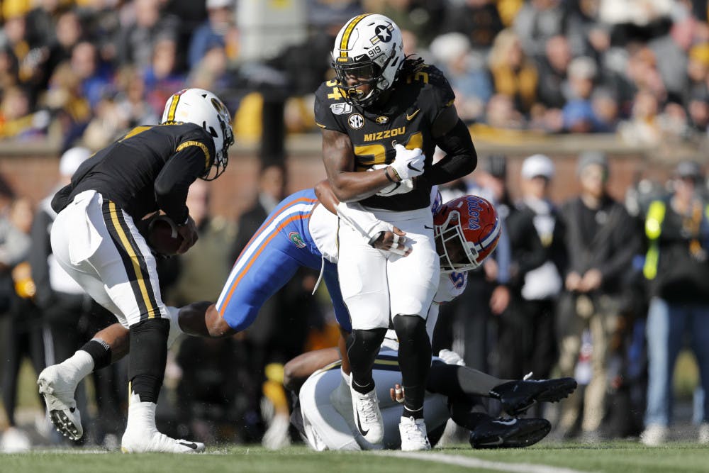 <p><span>Missouri running back Larry Rountree III, front, struggles for yardage before being pulled down by Florida linebacker Jonathan Greenard during the first half of an NCAA college football game Saturday, Nov. 16, 2019, in Columbia, Mo. (AP Photo/Jeff Roberson)</span></p>