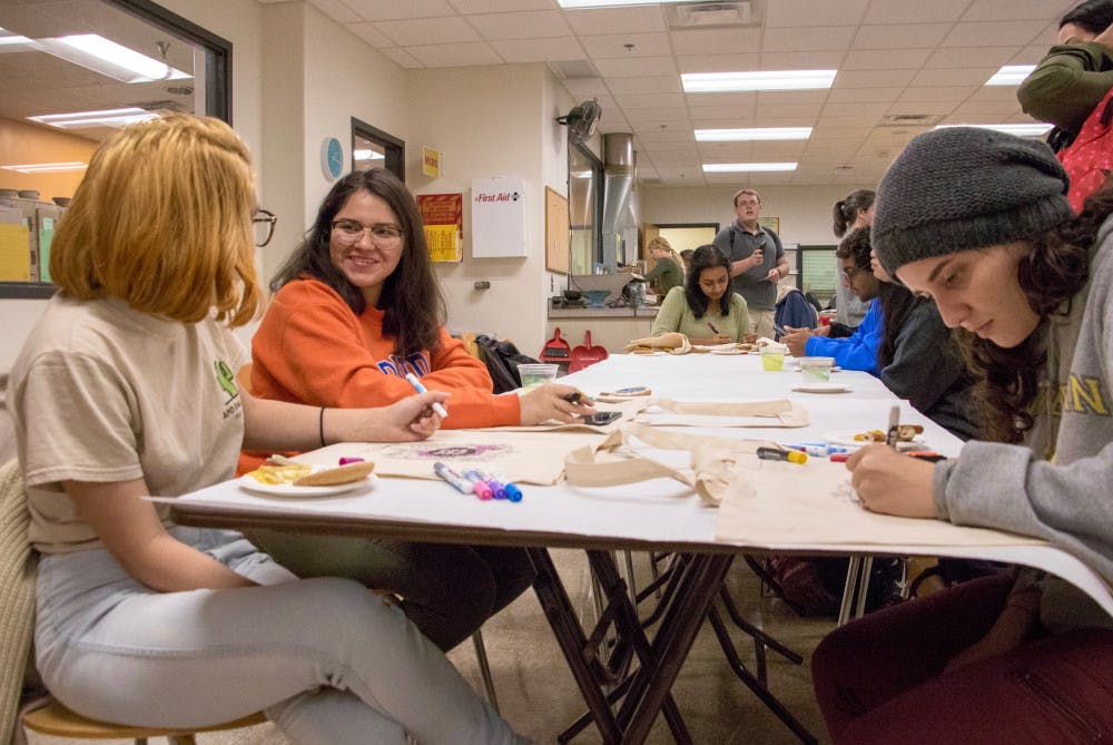 UF students Diana Rodas, a zoology junior, Natalie Guzman, a public relations sophomore, and Patricia Lauzardo, a sociology senior, draw on canvas bags at the Reitz Union Arts &amp; Crafts Center Grand Reopening Extravaganza on Wednesday afternoon.