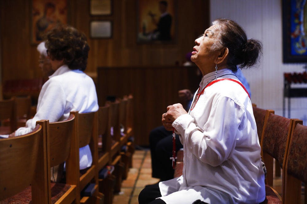 <p>Esther Gianan, of Tampa, a retired registered nurse, prays for those who are affected by the coronavirus during Mass at St. Lawrence Catholic Church in Tampa, Fla., Friday, March 6, 2020. (Octavio Jones/Tampa Bay Times via AP)</p>