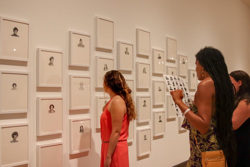 Visitors look at Lisa Iglesias’ exhibit, “groundbreaking,” at the Harn Museum of Art. She said she uses her artwork to deliver social justice themes. 