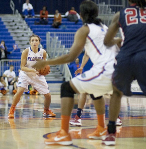 Guard Carlie Needles (left) passes the ball to forward Jennifer George (middle) during Florida’s 88-81 loss to Ole Miss on Jan. 24 at home.