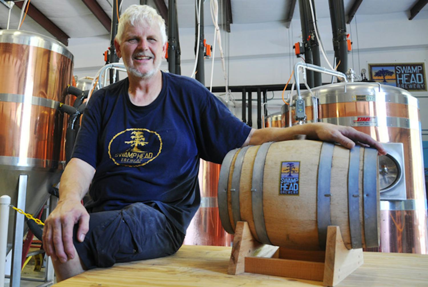 Head brewer Craig Birkmaier poses next to a cask of beer at Swamp Head Brewery on Thursday. He recovered part of a batch of beer Monday after power was cut for more than an hour.