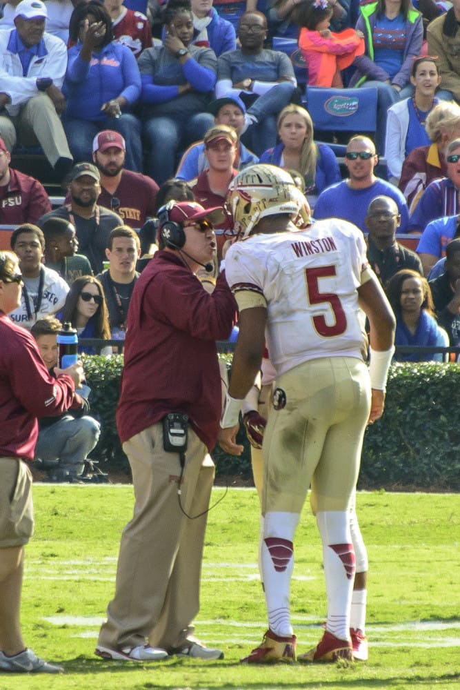 Florida State coach Jimbo Fisher talks to quarterback Jameis Winston (5) during FSU's 37-7 win against UF on Nov. 30 at Ben Hill Griffin Stadium.