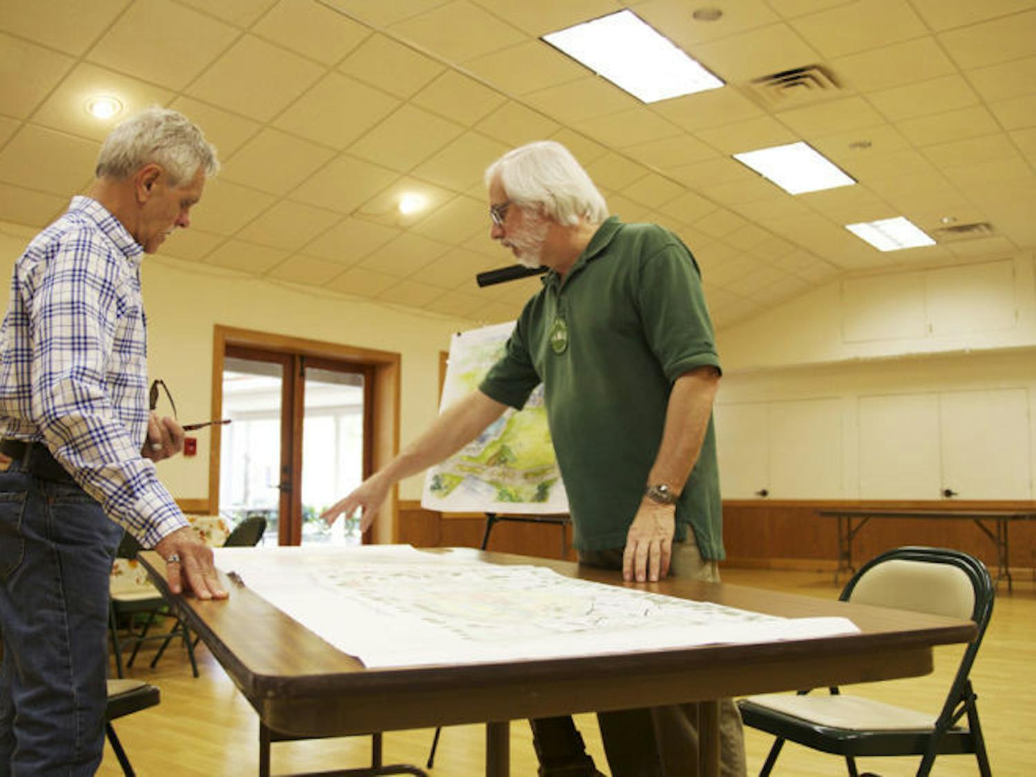 Andrew Kaplan shows a potential buyer an architectural rendering of the upcoming cohousing community, which will be located at 4500 NW 27th Ave. 