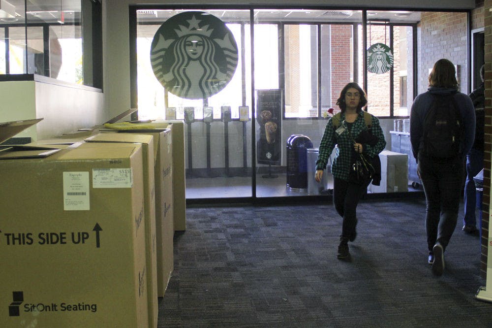 Marston Science Library visitors walk by the entrance to Starbucks on the first floor Wednesday. The Starbucks on the ground floor of Marston will open Monday.