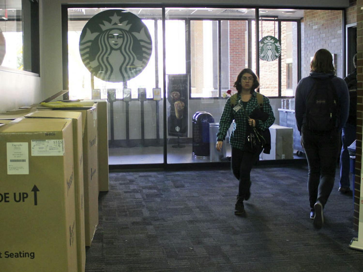 Marston Science Library visitors walk by the entrance to Starbucks on the first floor Wednesday. The Starbucks on the ground floor of Marston will open Monday.
