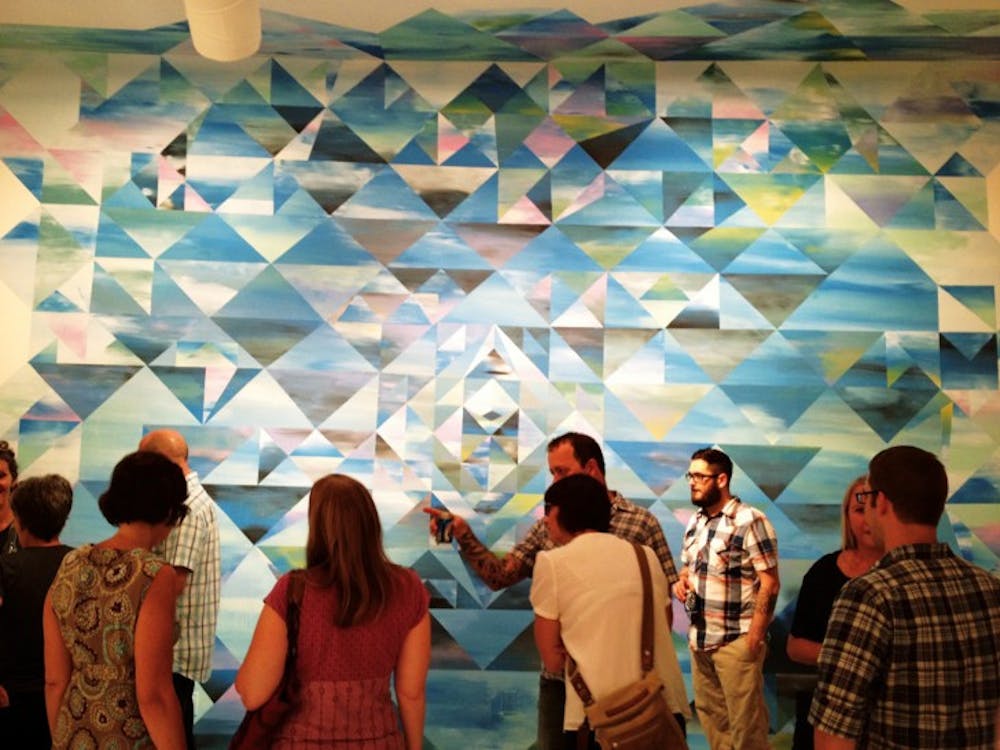 <p>Spectators gather around artwork at F.L.A. Gallery, 10 N. Main St., during the opening night of “Rewilding, F.L.A.,” the gallery’s first show.</p>