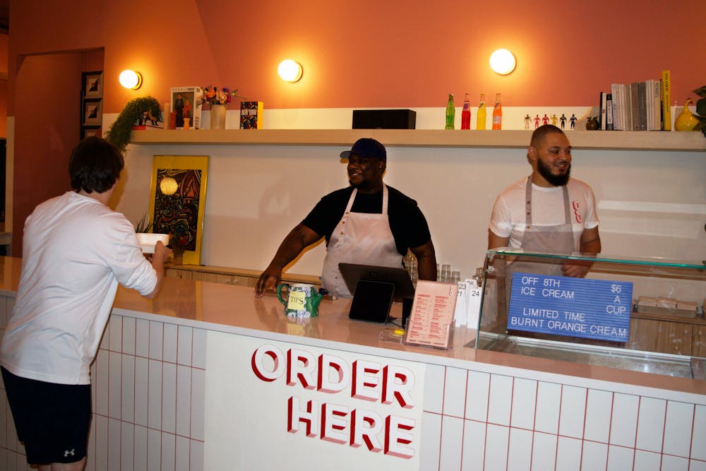 <p>Workers at Germain’s Chicken Sandwiches serving a guest at their new location at 220 NW 8th Avenue Friday, Dec. 30, 2022.</p>