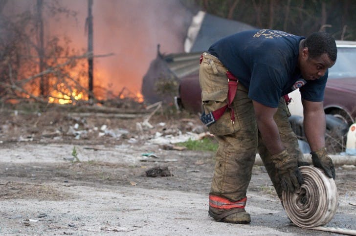 An Alachua County Fire Rescue Worker packs up equipment at 3530 SE Hawthorne Road after tending to a commercial tire fire Tuesday evening.