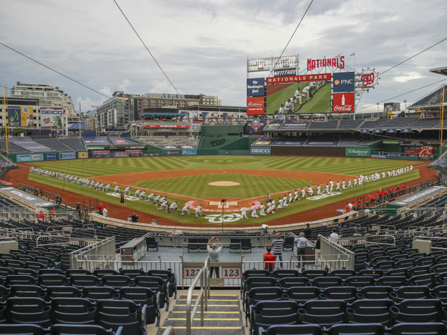 The New York Yankees and the Washington Nationals kneel while holding a black ribbon to honor Black Lives Matter before playing an opening day baseball game at Nationals Park, Thursday, July 23, 2020, in Washington. before the start of the first inning of an opening day baseball game at Nationals Park, Thursday, July 23, 2020, in Washington. (AP Photo/Alex Brandon)
