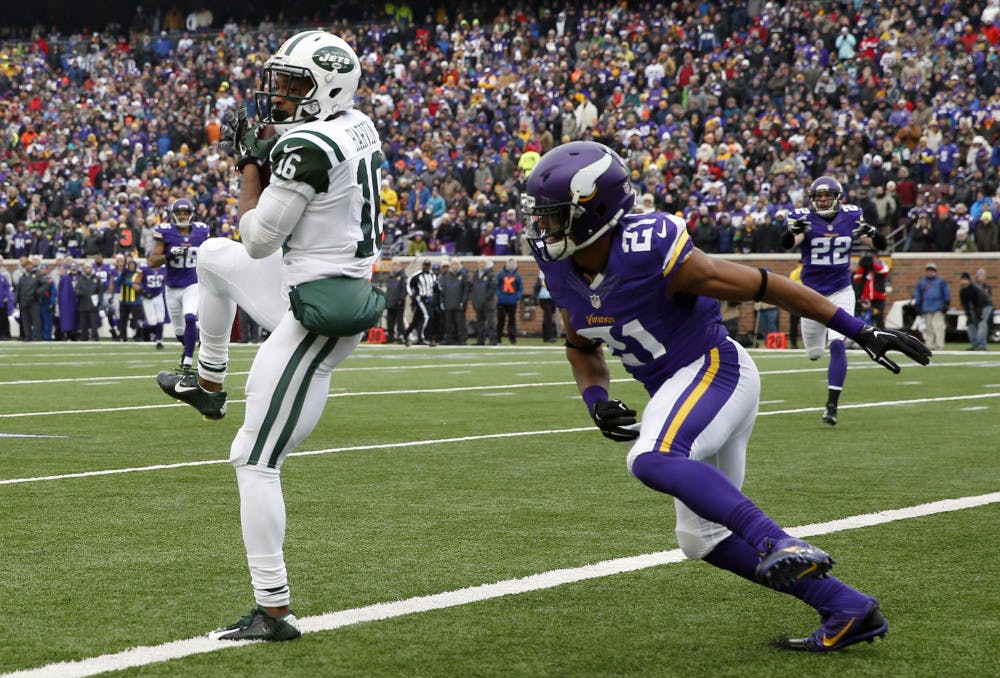New York Jets wide receiver Percy Harvin, left, catches a 35-yard touchdown pass in front of Minnesota Vikings cornerback Josh Robinson during the first half of an NFL football game, Sunday, Dec. 7, 2014, in Minneapolis.