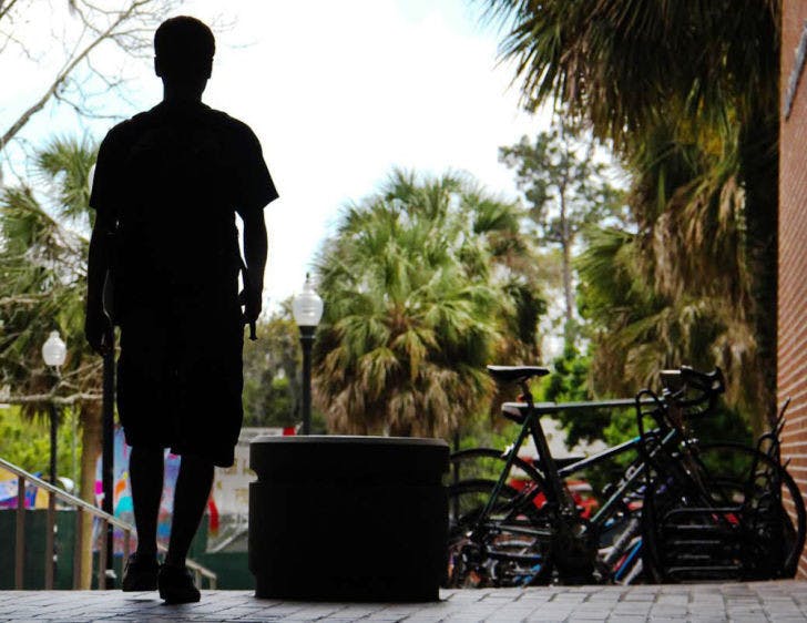 A student walks out of Weimer Hall following a class on campus Tuesday afternoon. Weimer houses the university’s College of Journalism and Communications.