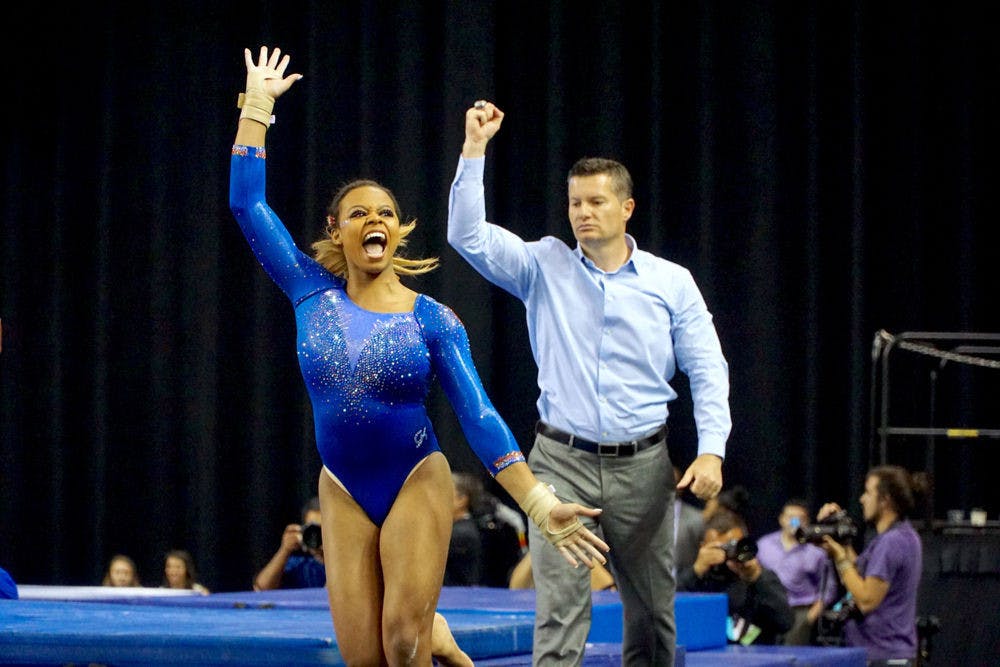 <p>Kennedy Baker (left) and assistant coach Adrian Burde (right) celebrate after Baker's vault routine&nbsp;during the NCAA Gymnastics Super Six on April 16, 2016, in Fort Worth, Texas.</p>