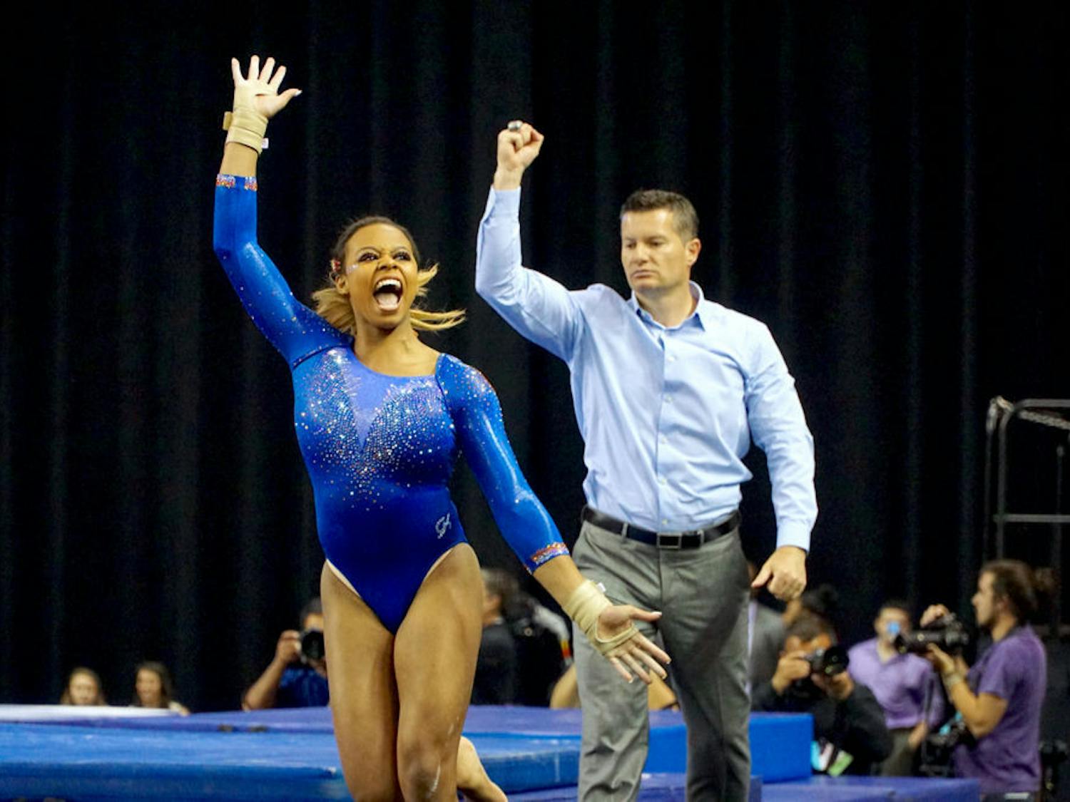 Kennedy Baker (left) and assistant coach Adrian Burde (right) celebrate after Baker's vault routine&nbsp;during the NCAA Gymnastics Super Six on April 16, 2016, in Fort Worth, Texas.