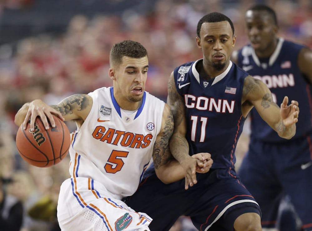 <p>Scottie Wilbekin, left, drives past Connecticut guard Ryan Boatright during the first half of Florida’s 63-52 loss to UConn on Saturday in Arlington, Texas. Wilbekin scored four points while recording one assist to three turnovers against the Huskies.</p>