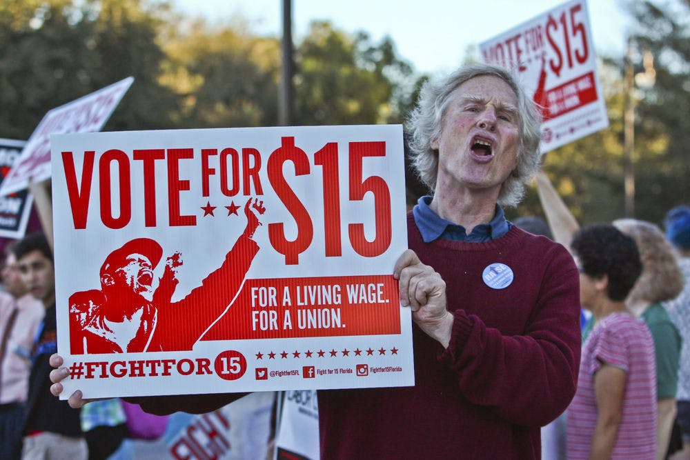 Frank Blankenship, the 63-year-old founder of MindFreedom Florida, protests for a $15 minimum wage at the corner of West University Avenue and 13th Street on Nov. 10, 2015. There were 60 people protesting, including local politicians, student group representatives, local faith leaders and Santa Fe College faculty.