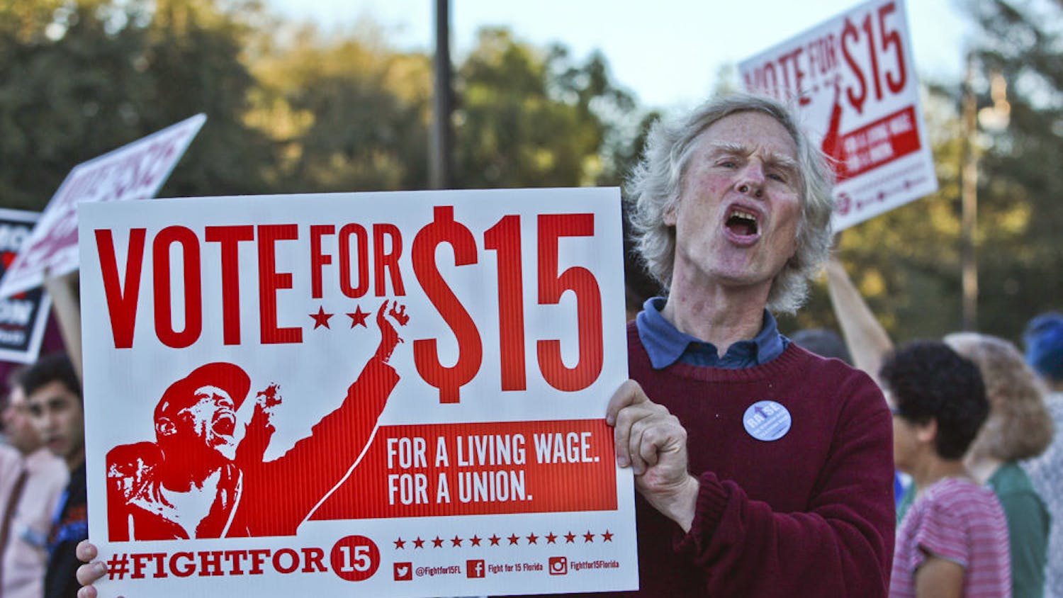 Frank Blankenship, the 63-year-old founder of MindFreedom Florida, protests for a $15 minimum wage at the corner of West University Avenue and 13th Street on Nov. 10, 2015. There were 60 people protesting, including local politicians, student group representatives, local faith leaders and Santa Fe College faculty.