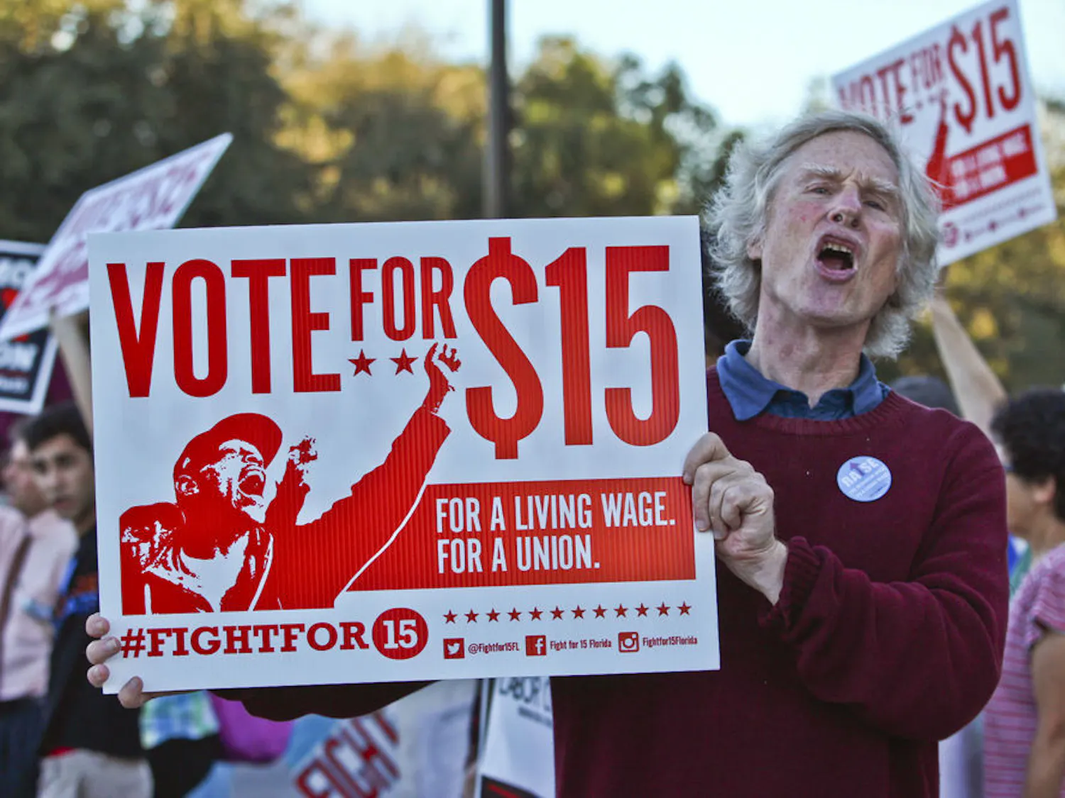 Frank Blankenship, the 63-year-old founder of MindFreedom Florida, protests for a $15 minimum wage at the corner of West University Avenue and 13th Street on Nov. 10, 2015. There were 60 people protesting, including local politicians, student group representatives, local faith leaders and Santa Fe College faculty.