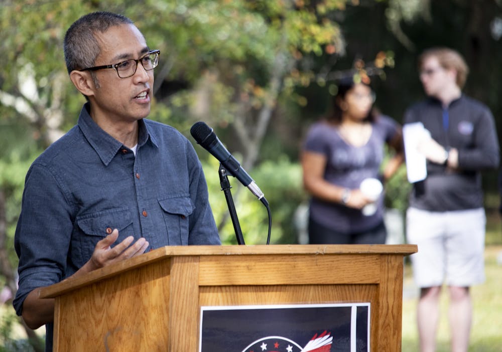 <p>James Dinh, artist of the new monument, speaks during the Veterans Day event at the Historic Evergreen Cemetery.</p>