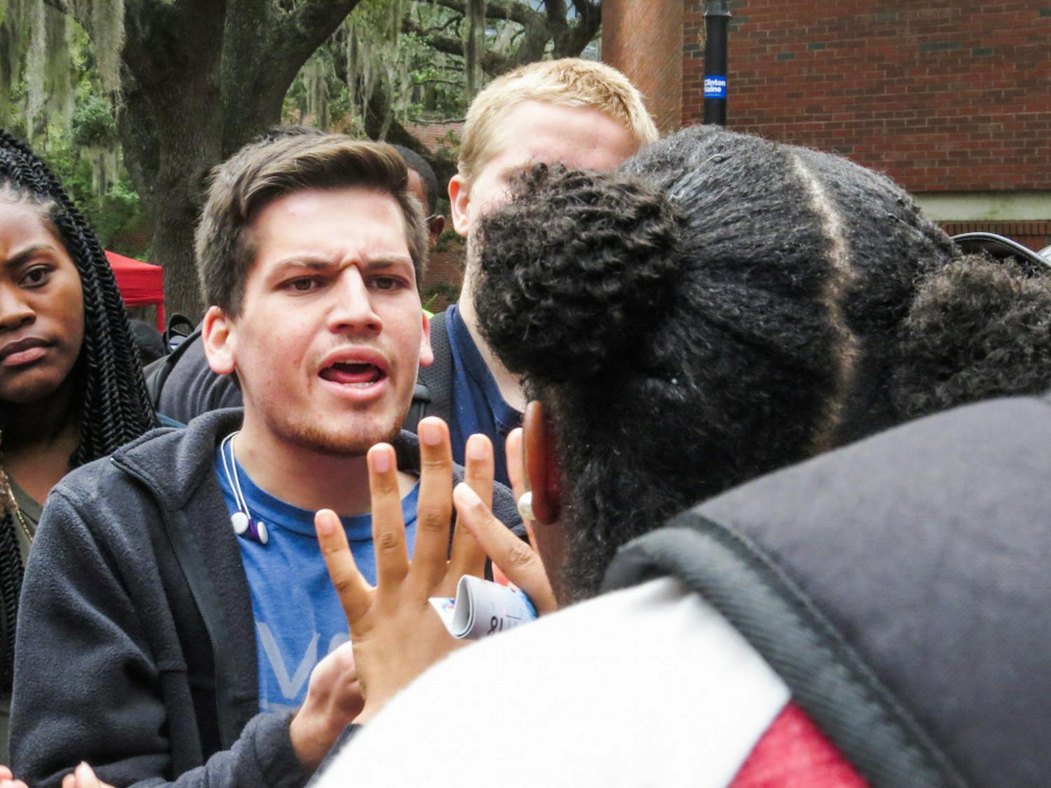 Chris Salazar, a 19-year-old UF finance freshman, argues in a tight group on Turlington Plaza during a protest against President-elect Donald Trump on Monday. "He's my president,” Salazar said after arguing. “Democracy decided. I'm going to support him." Read more on page 3. 