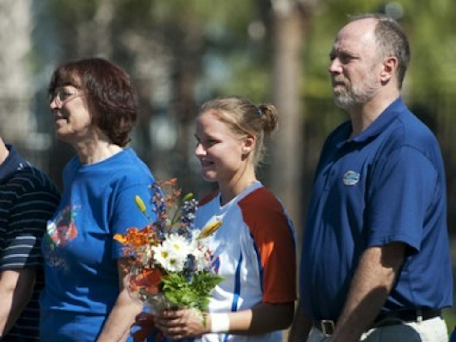 Florida midfielder Sarah Chapman (center) is presented a framed jersey during Florida’s Senior Day on Oct. 23 as parents Rick (right) and Lynn (left) look on.