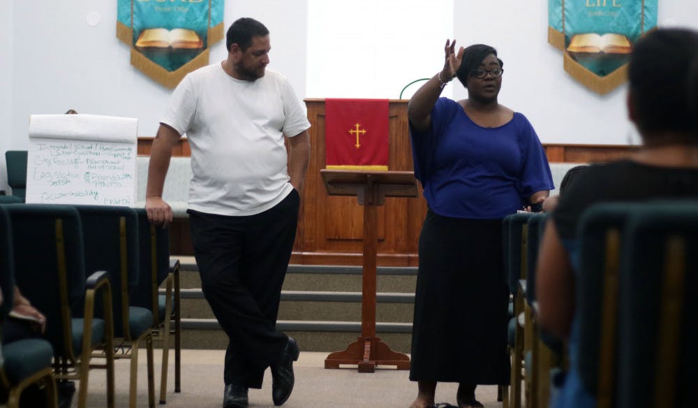 Larry Green, 48, and Chanae Jackson-Baker, 39, address the assembled attendants at a meeting to reform a recent racial equity plan by the Alachua County School Board on Monday night at DaySpring Missionary Baptist Church in Gainesville. 
